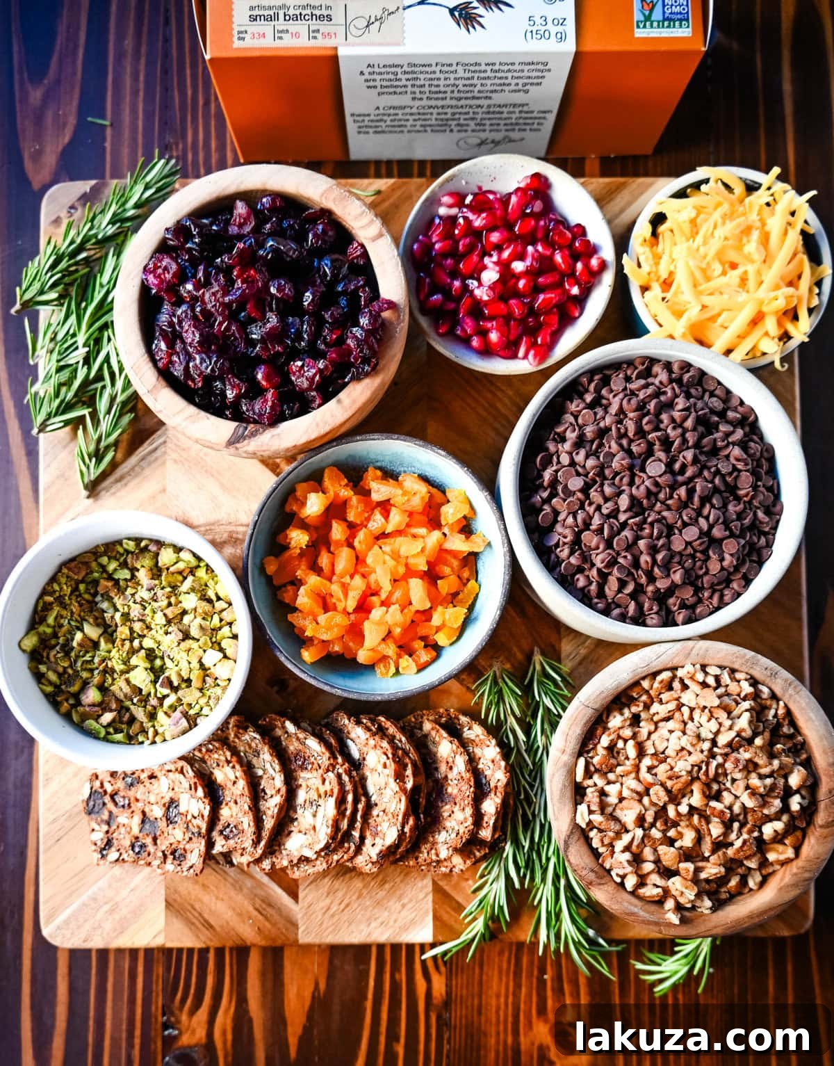 Irresistible Mini Cheese Bites 5 A diverse selection of ingredients and toppings for mini cheese balls, including various cheeses, nuts, herbs, and dried fruits, laid out on a wooden board.