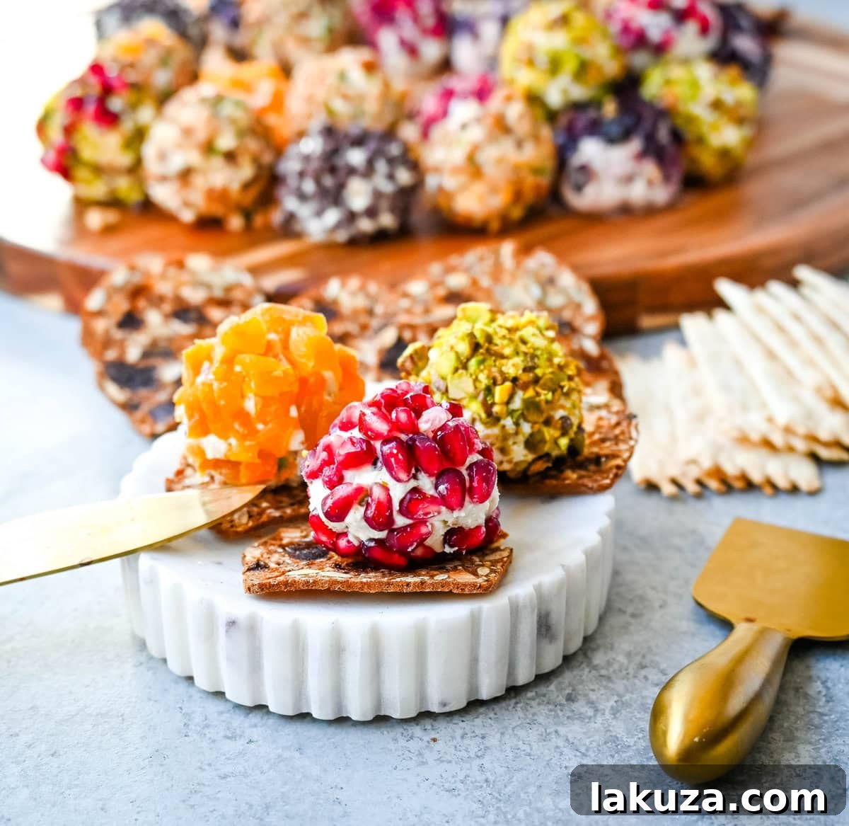 Irresistible Mini Cheese Bites 6 An assortment of mini cheese balls, some rolled in nuts and others in herbs, elegantly displayed on raincoast crisps for serving.
