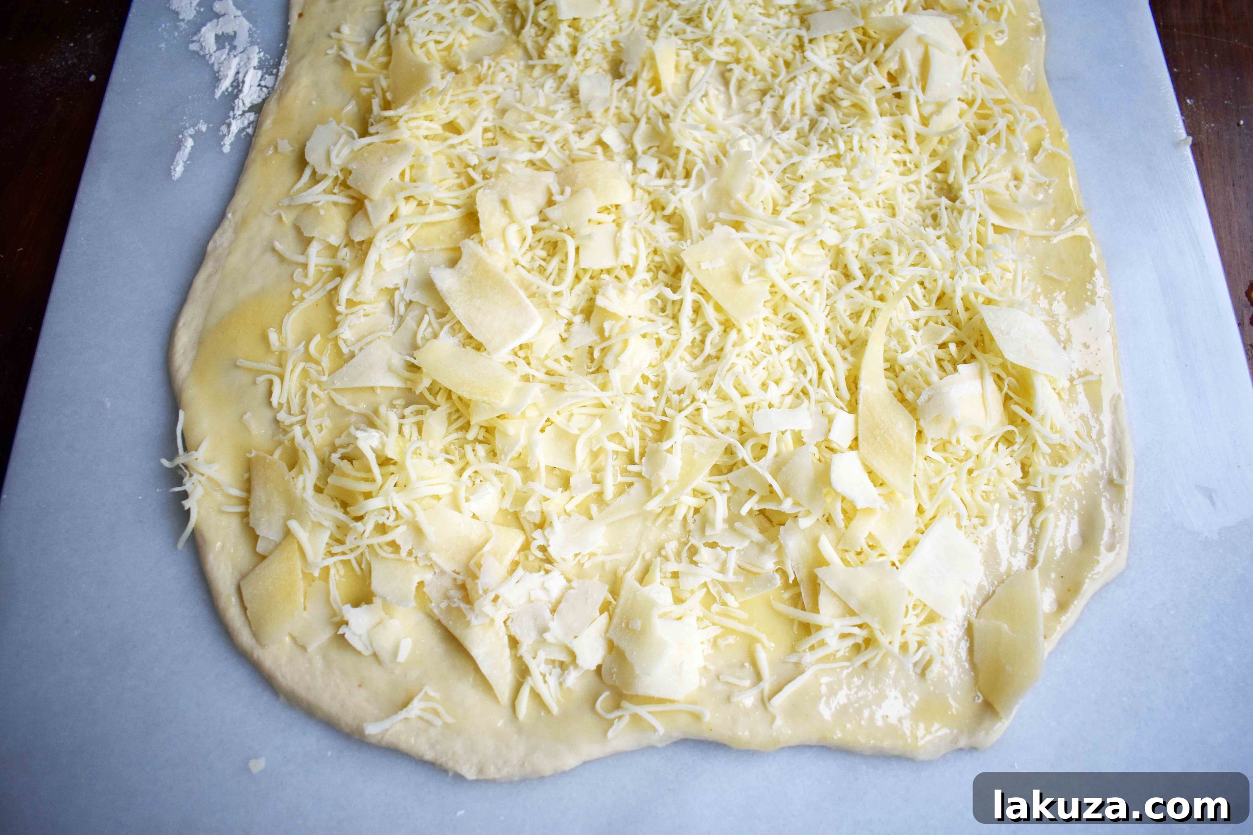 Golden's Savory Garlic Parmesan Cheese Rolls 5 Spread garlic butter and cheese on pizza dough before rolling.