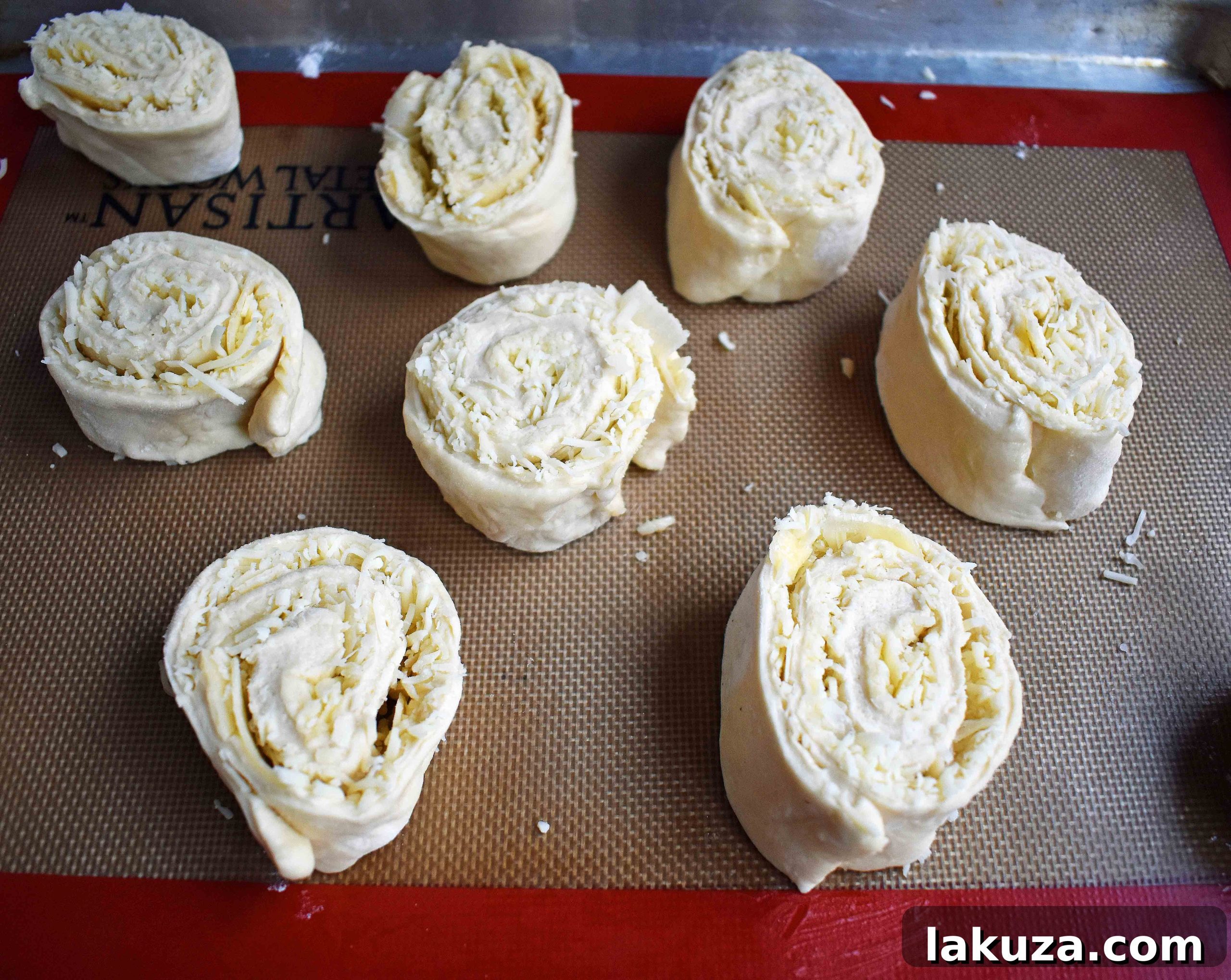 Golden's Savory Garlic Parmesan Cheese Rolls 6 Garlic parmesan cheese rolls baking on a sheet pan.