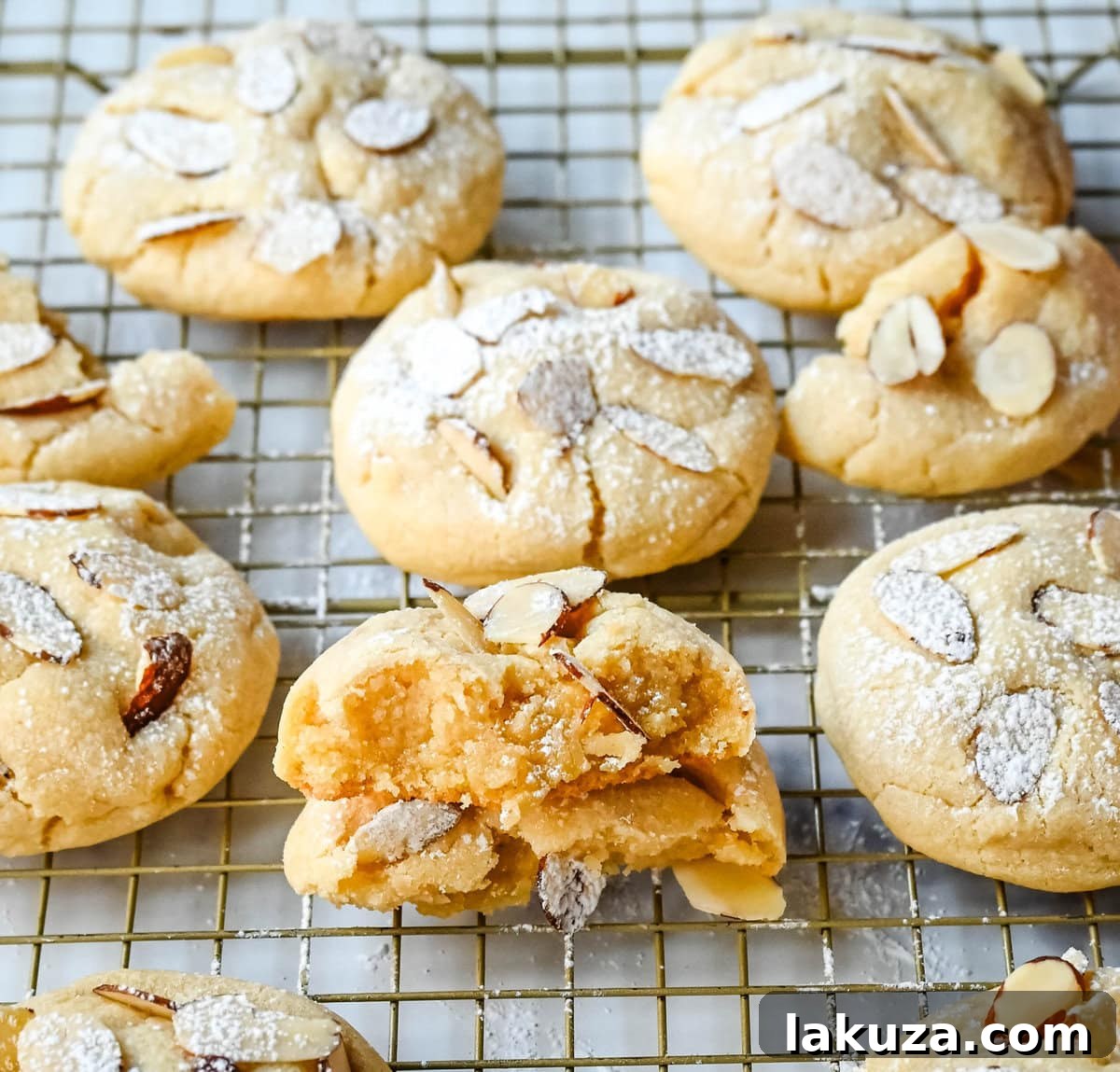 Almond Croissant-Inspired Cookies 7 A single perfectly baked Almond Croissant Cookie, dusted with powdered sugar and topped with sliced almonds.