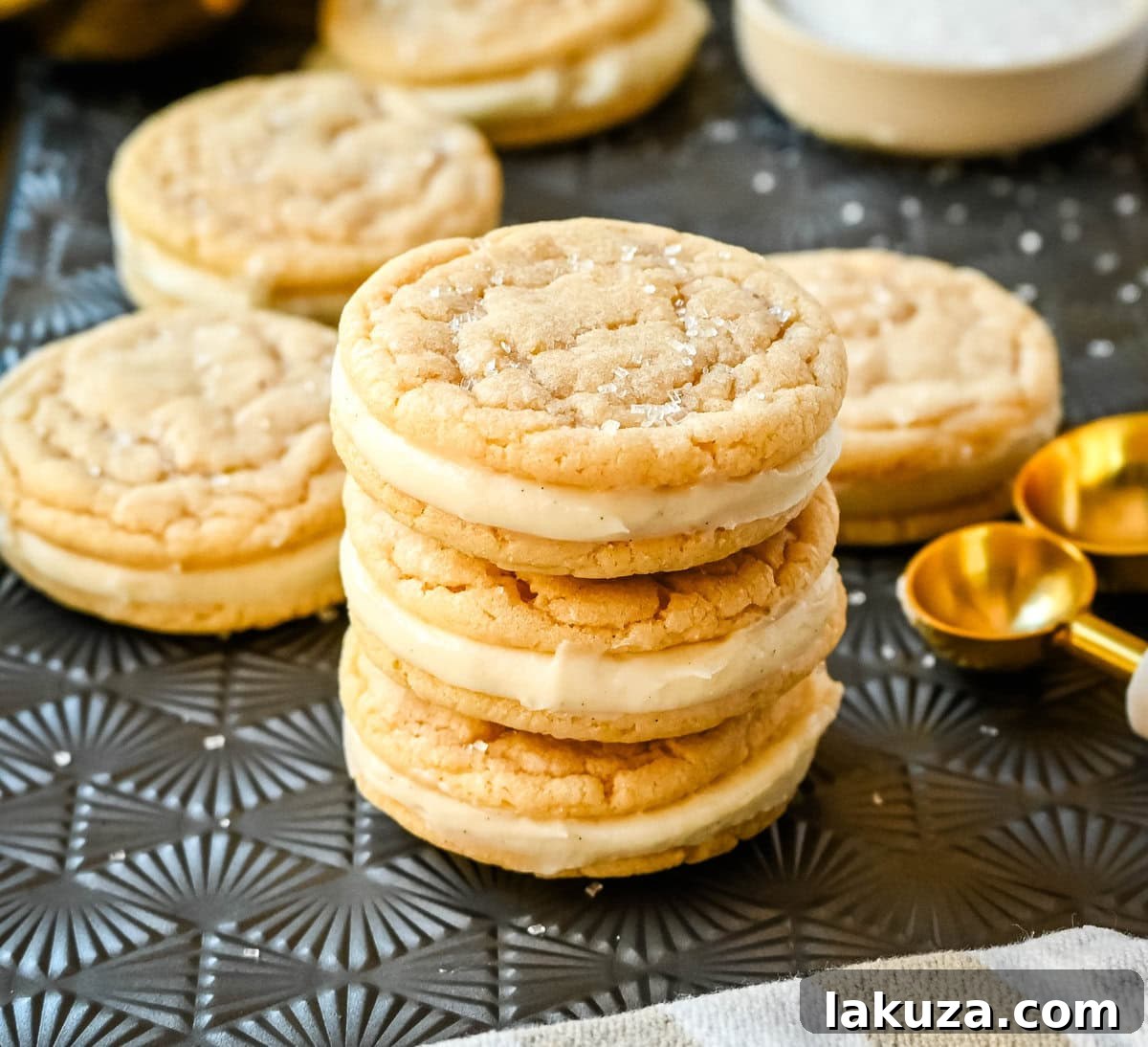 Cream Cheese Frosted Sugar Cookie Sandwiches 3 A close-up of a stack of Sugar Sandwich Cookies featuring tender vanilla sugar cookies and a generous layer of cream cheese frosting.