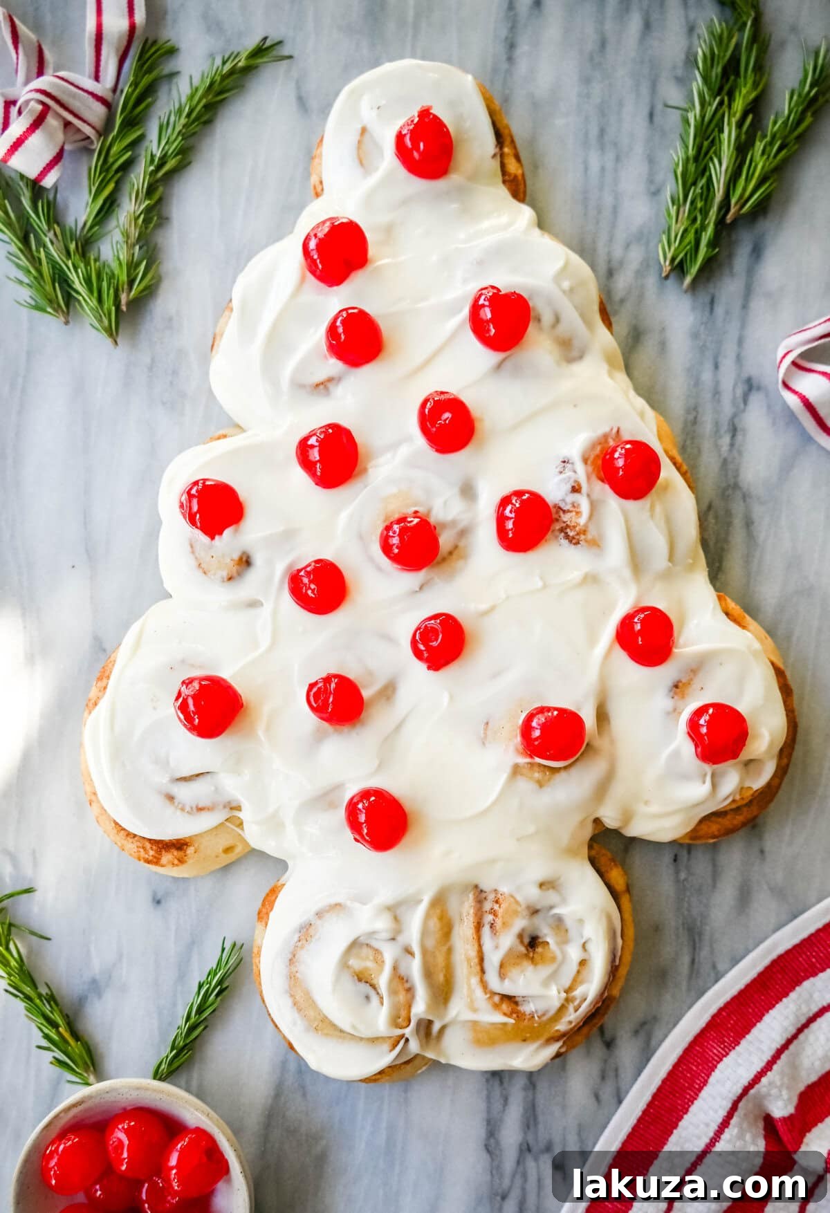 Are you looking for a sweet, festive, and delicious Christmas breakfast recipe for your Christmas morning? This Cinnamon Roll Christmas Tree is made with either homemade cinnamon roll dough or store-bought options like Rhodes frozen cinnamon rolls and covered in a creamy frosting. It can even be decorated with "red ornaments" -- maraschino cherries.