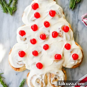 Are you looking for a sweet, festive, and delicious Christmas breakfast recipe for your Christmas morning? This Cinnamon Roll Christmas Tree is made with either homemade cinnamon roll dough or store-bought options like Rhodes frozen cinnamon rolls and covered in a creamy frosting. It can even be decorated with "red ornaments" -- maraschino cherries.