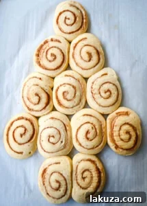Arranging cinnamon roll dough into a Christmas tree shape to make a Cinnamon Roll Christmas Tree