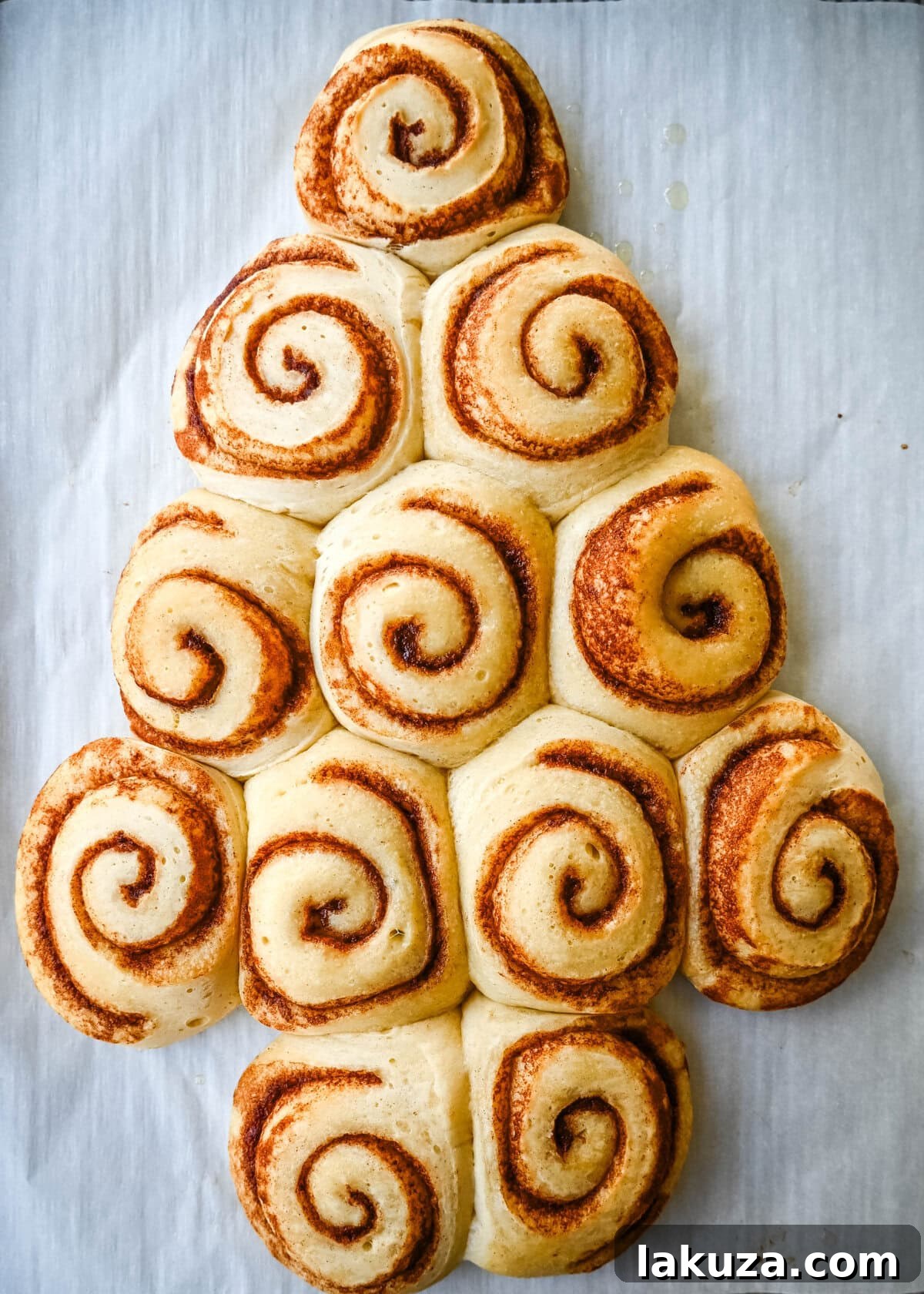 Bake the cinnamon rolls in a Christmas tree shape to make a Cinnamon Roll Christmas Tree