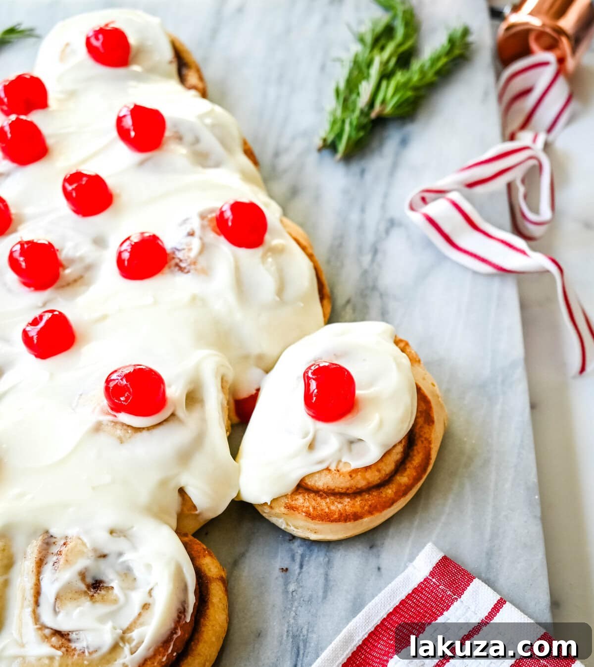 Are you looking for a sweet, festive, and delicious Christmas breakfast recipe for your Christmas morning? This Cinnamon Roll Christmas Tree is made with either homemade cinnamon roll dough or store-bought options like Rhodes frozen cinnamon rolls and covered in a creamy frosting. It can even be decorated with "red ornaments" -- maraschino cherries.