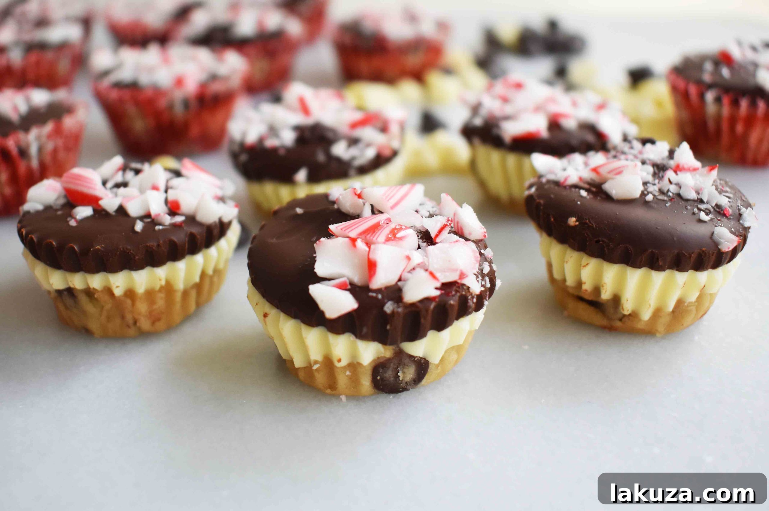 Multiple Peppermint Bark Cookie Dough Cups stacked and displayed, highlighting their festive colors and textures.