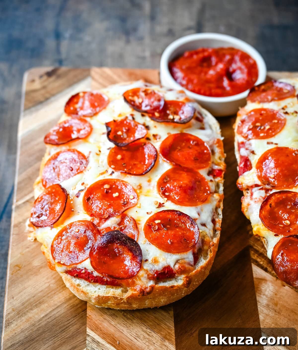 Crispy French Bread Pizzas 4 Ingredients for French bread pizza laid out: a loaf of French bread, melted garlic butter, pizza sauce, mozzarella cheese, and pepperoni.