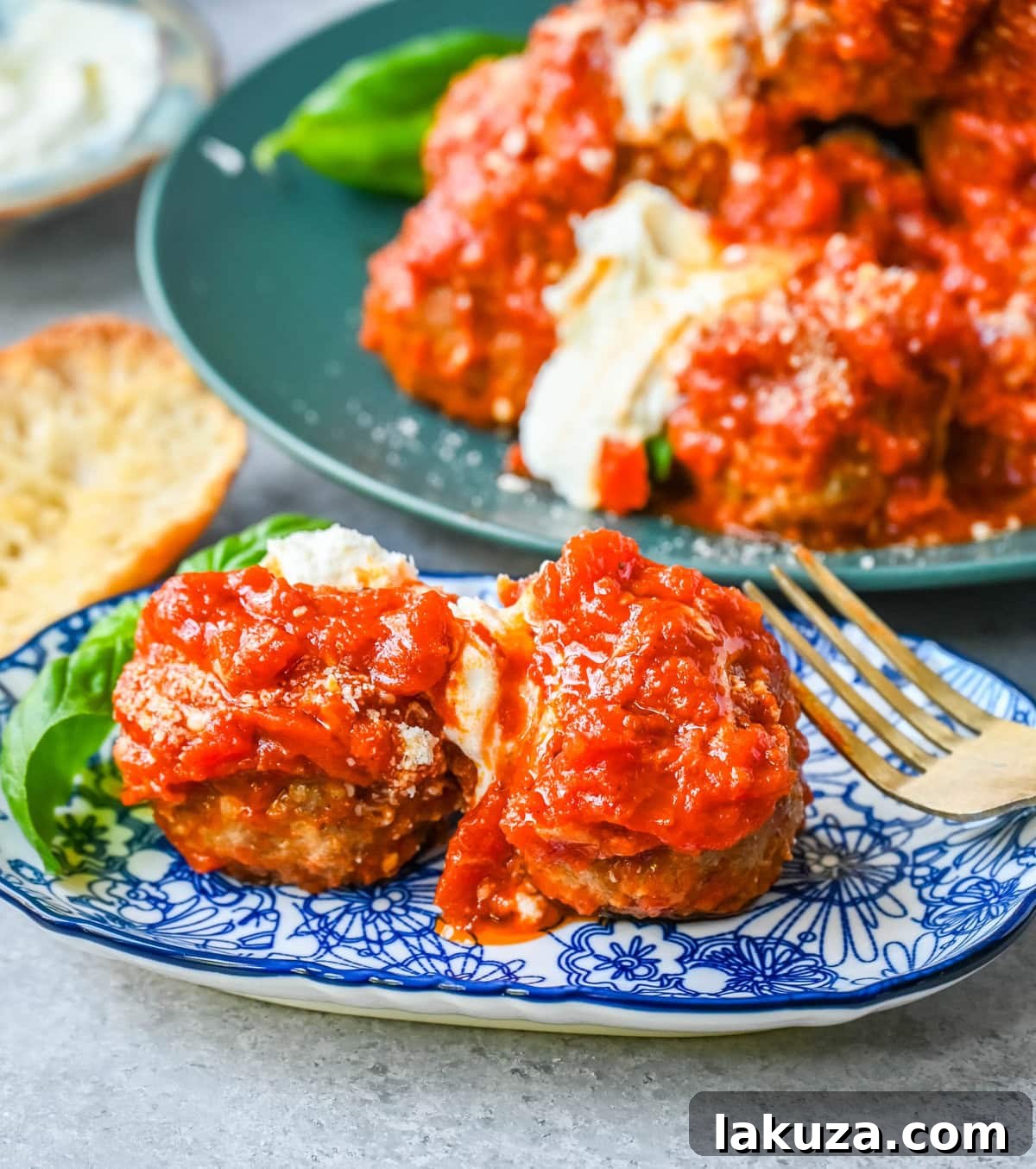 A serving of Ricotta Parmesan Meatballs in a bowl, topped with fresh basil and extra Parmesan.