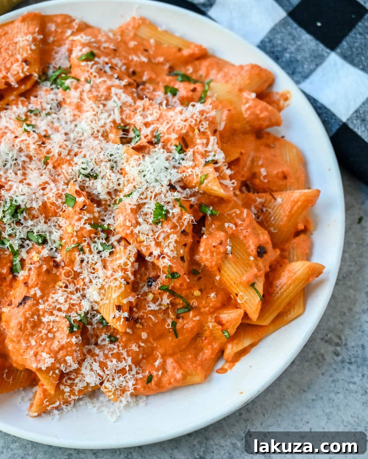 A large pot of simmering Penne alla Vodka sauce, showcasing its vibrant red hue and creamy texture, just before the pasta is added.