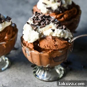 A bowl of rich chocolate mousse, topped with whipped cream and chocolate shavings, embodying a simple yet decadent dessert.