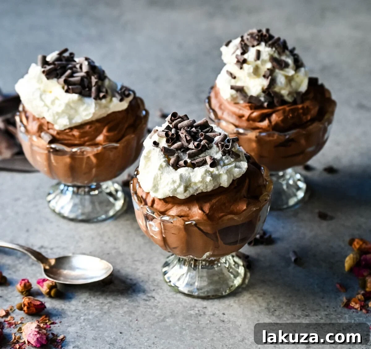 A close-up showing the luscious chocolate mousse being spooned into individual serving ramekins, highlighting its smooth and luxurious consistency.