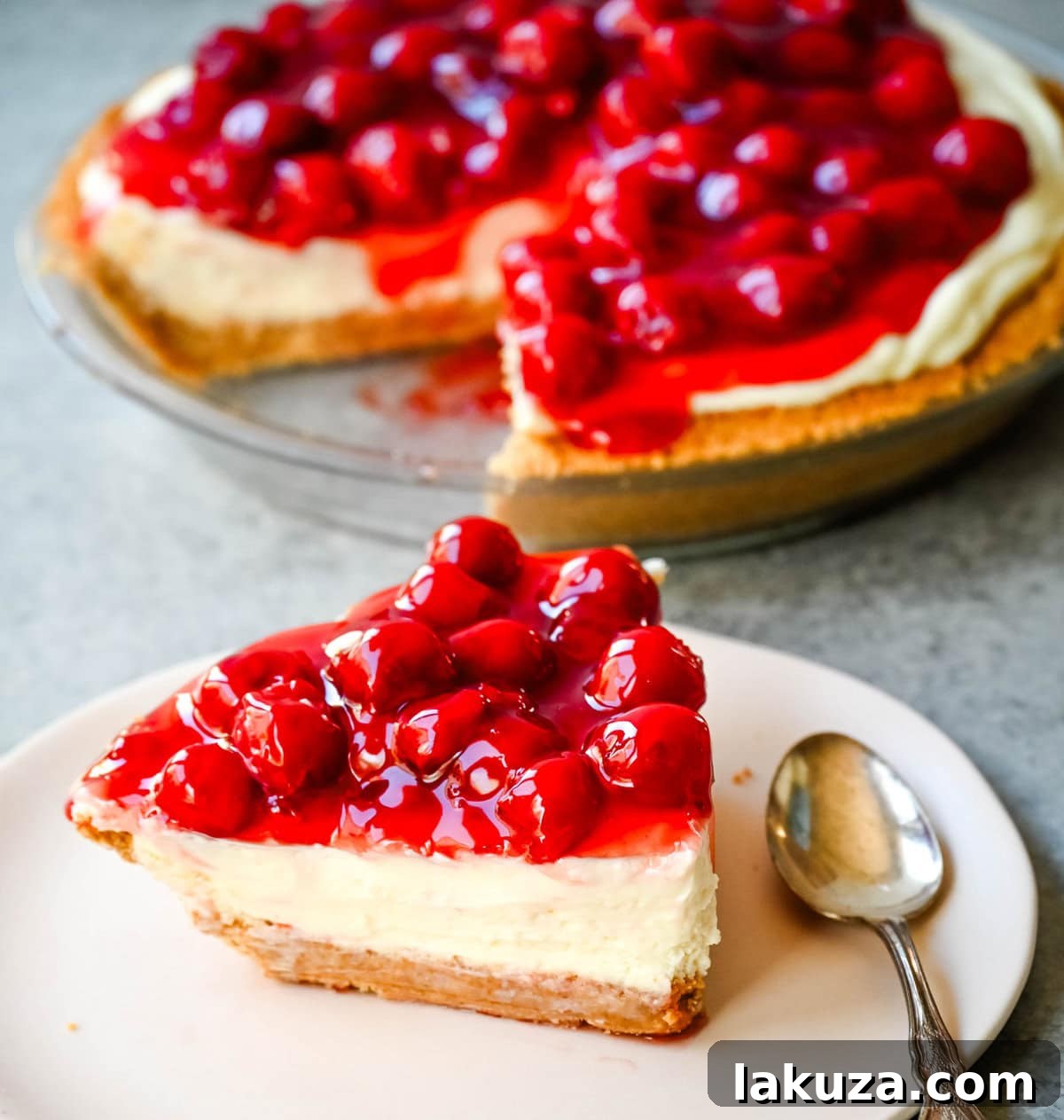 Dreamy No-Bake Cheesecake with Sweetened Condensed Milk 6 A No-Bake Cheesecake generously topped with a rich, vibrant cherry pie filling, ready to be sliced and served.