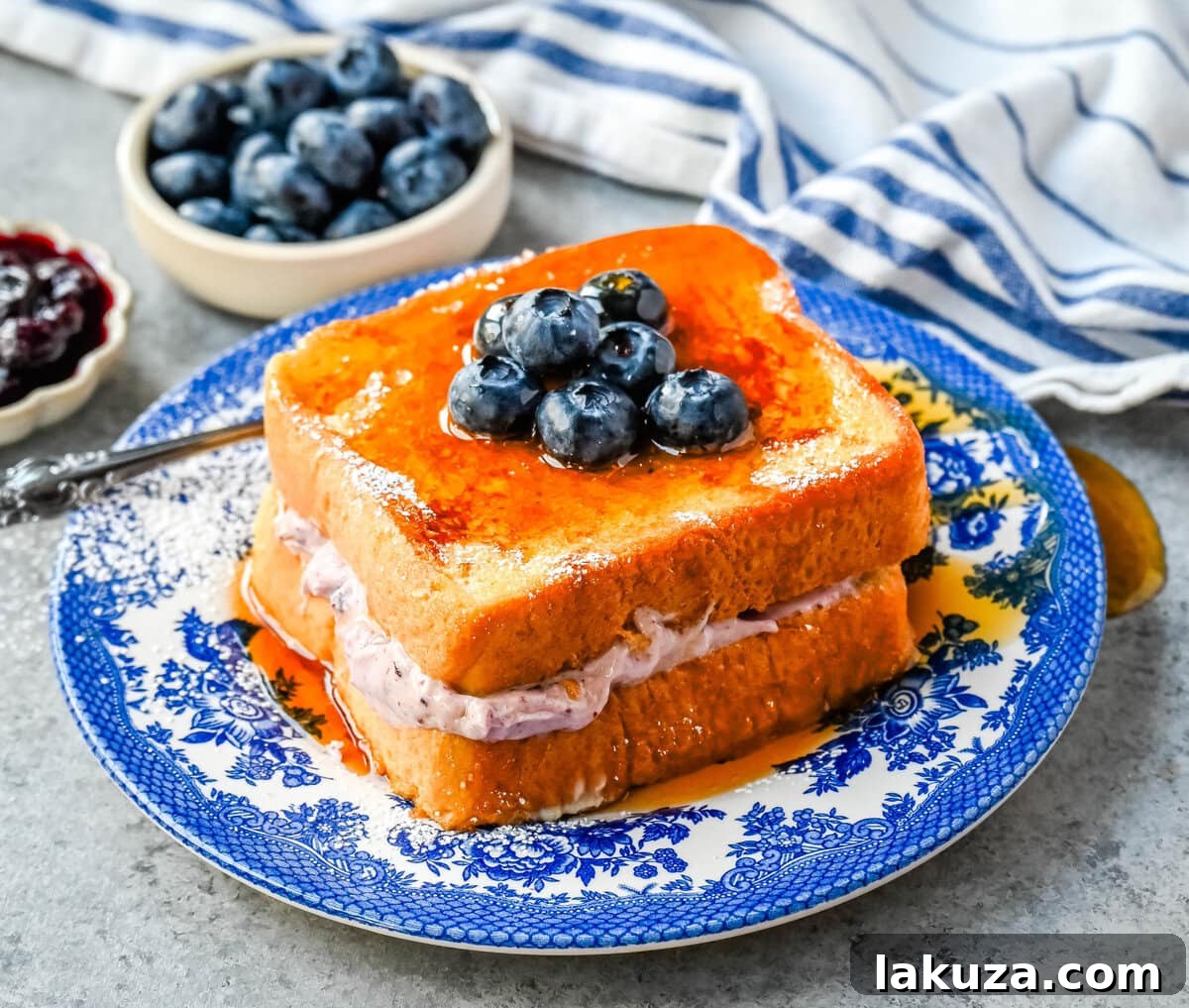 Decadent Blueberry Cheesecake French Toast 2 Decadent Blueberry Cream Cheese Stuffed French Toast with fresh berries and maple syrup.