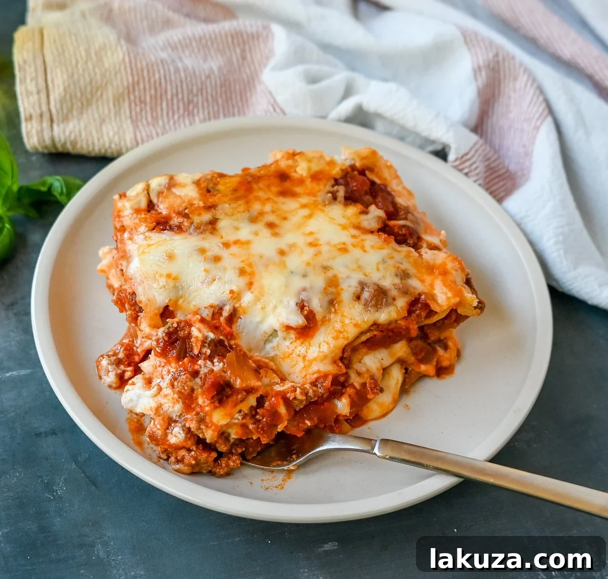 Delicious Italian Bolognese Lasagna with creamy bechamel sauce, topped with melted cheese, ready to be served from a baking dish.