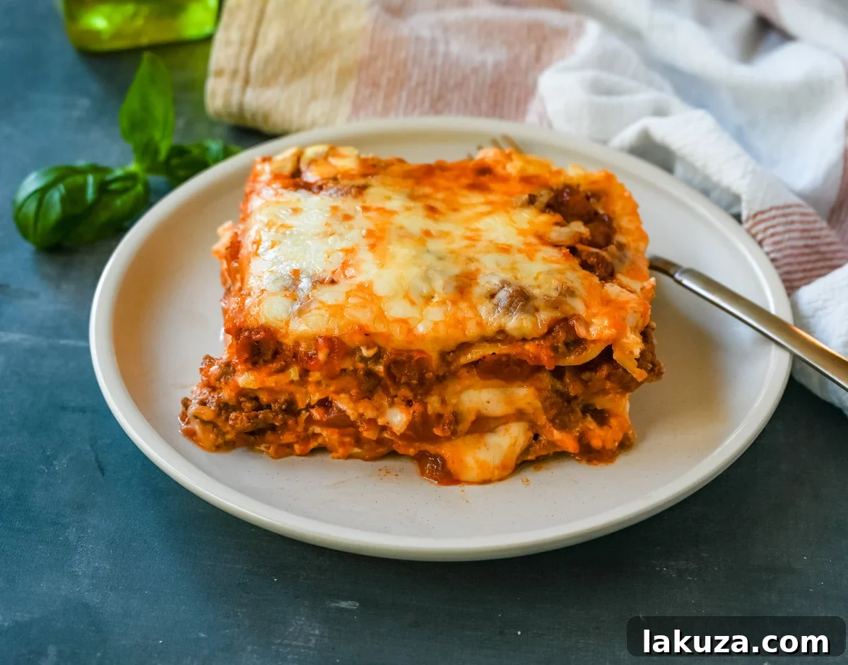 Layers of meat sauce, bechamel, pasta, and cheese, meticulously arranged and ready for baking in an Italian Bolognese Lasagna.