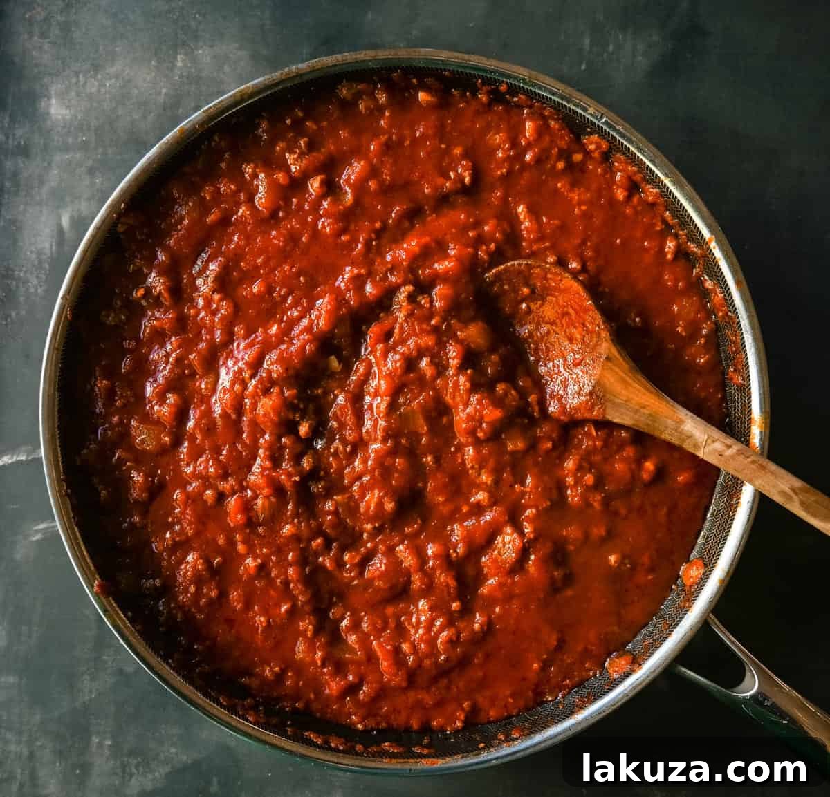 Sizzling ground beef and onions cooking for the Bolognese meat sauce, foundational layer for a rich and flavorful lasagna.