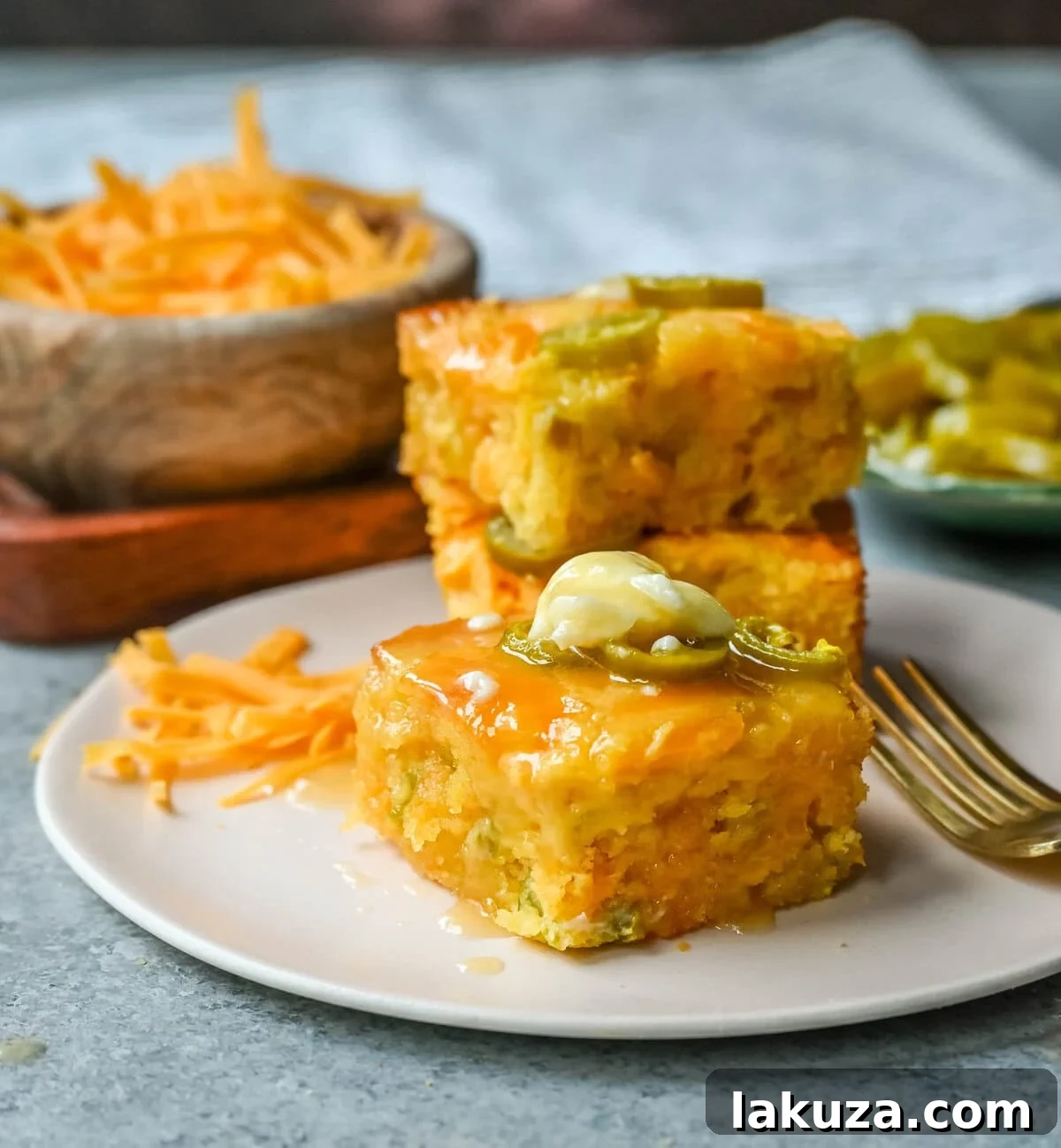 A whole pan of golden brown jalapeno cheddar cornbread, freshly baked and topped with extra melted cheese and sliced jalapenos.