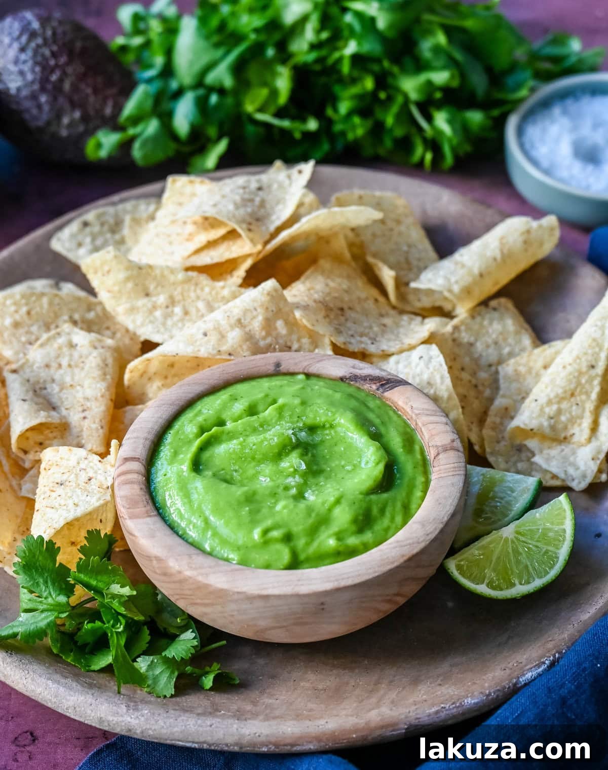 Close-up of creamy avocado salsa in a bowl with a spoon.
