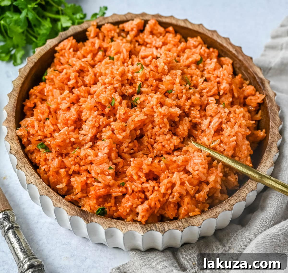 A close-up shot of fluffy, red Spanish Rice, garnished with fresh cilantro, ready to be served as a vibrant side dish.