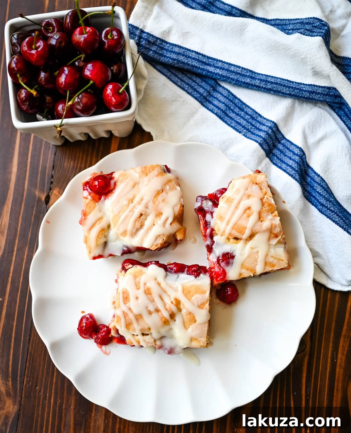 A tray of beautifully arranged Cherry Pie Bars with a Cookie Crust, garnished with icing drizzle.
