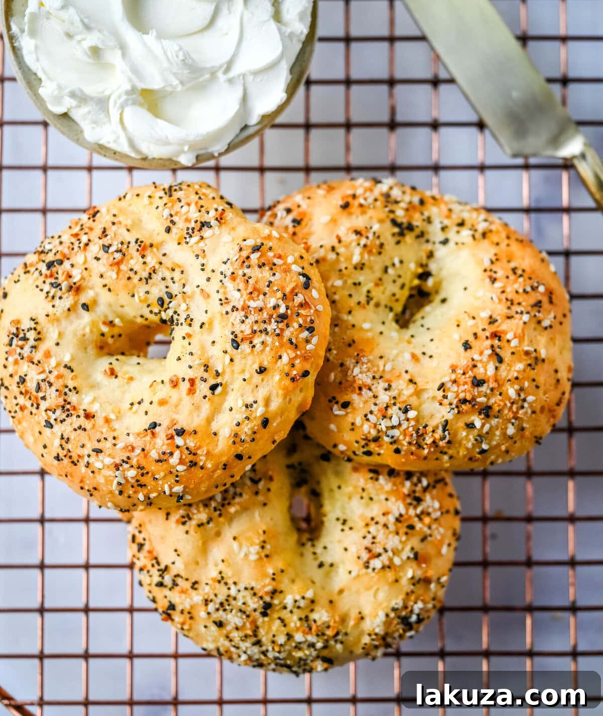 A stack of golden brown cottage cheese bagels on a cooling rack