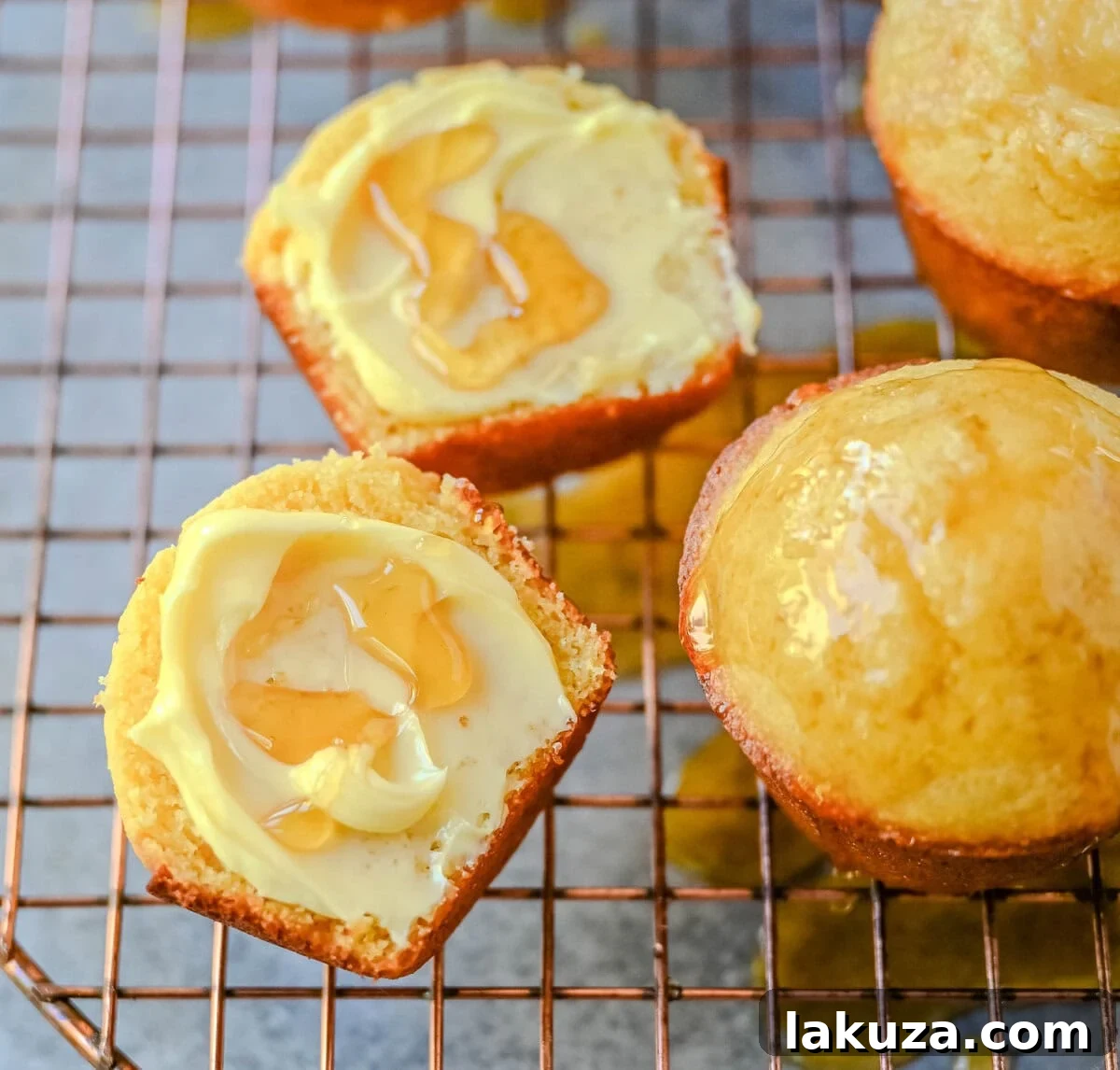 Buttery Cornbread Muffins 5 A close-up shot of golden, perfectly baked corn muffins cooling on a wire rack, steam gently rising, highlighting their fluffy texture.