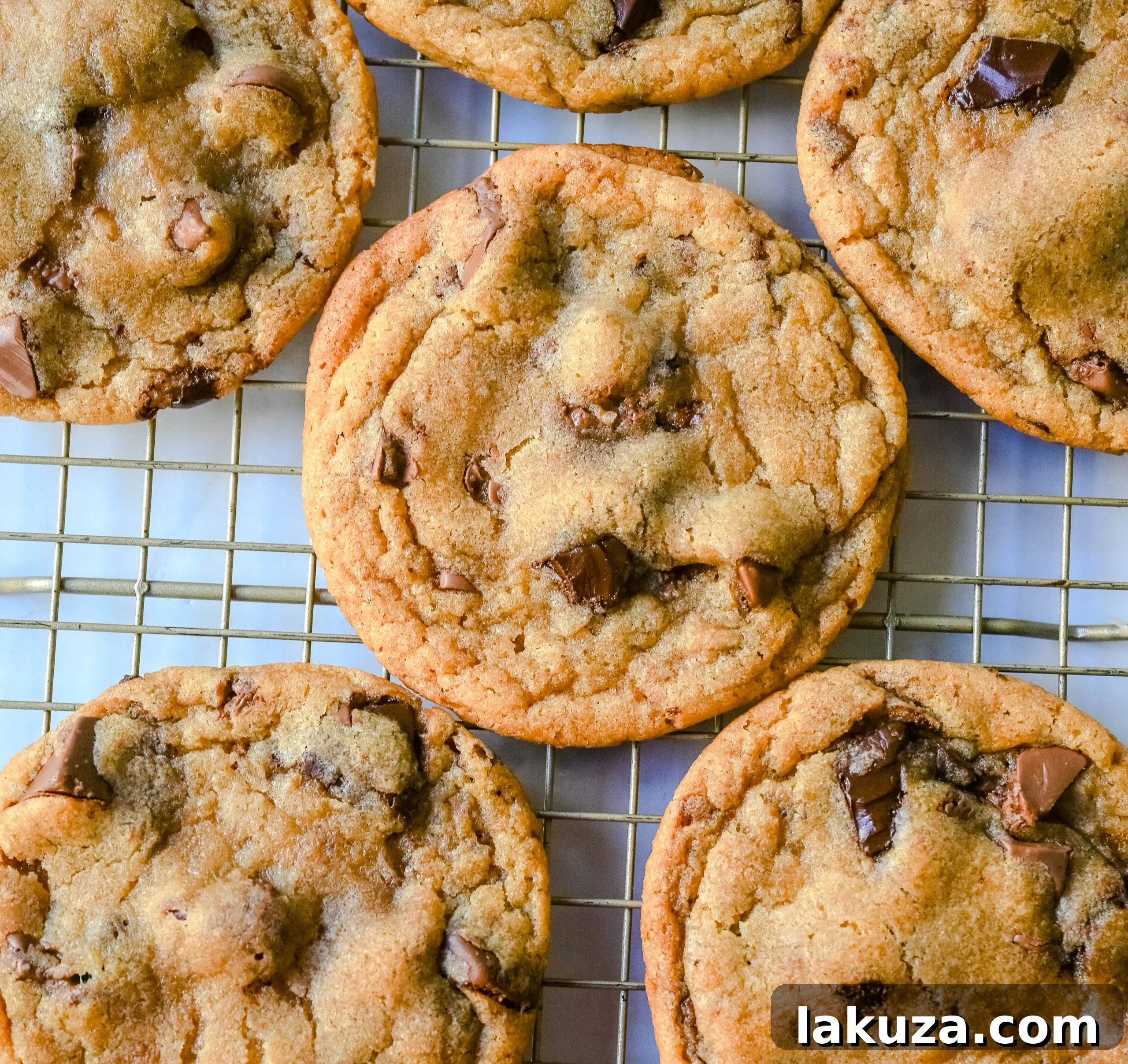 The Ultimate Thin and Chewy Chocolate Chip Cookies 5 Beautifully arranged raw cookie dough balls with visible chocolate chunks on a parchment-lined baking sheet, ready for baking into thin and chewy chocolate chip cookies.