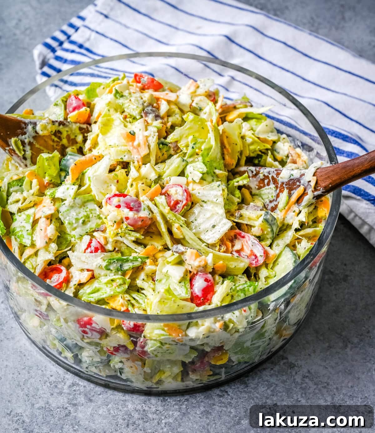 Finished seven layer salad in a glass bowl, drizzled with ranch dressing and ready to serve.