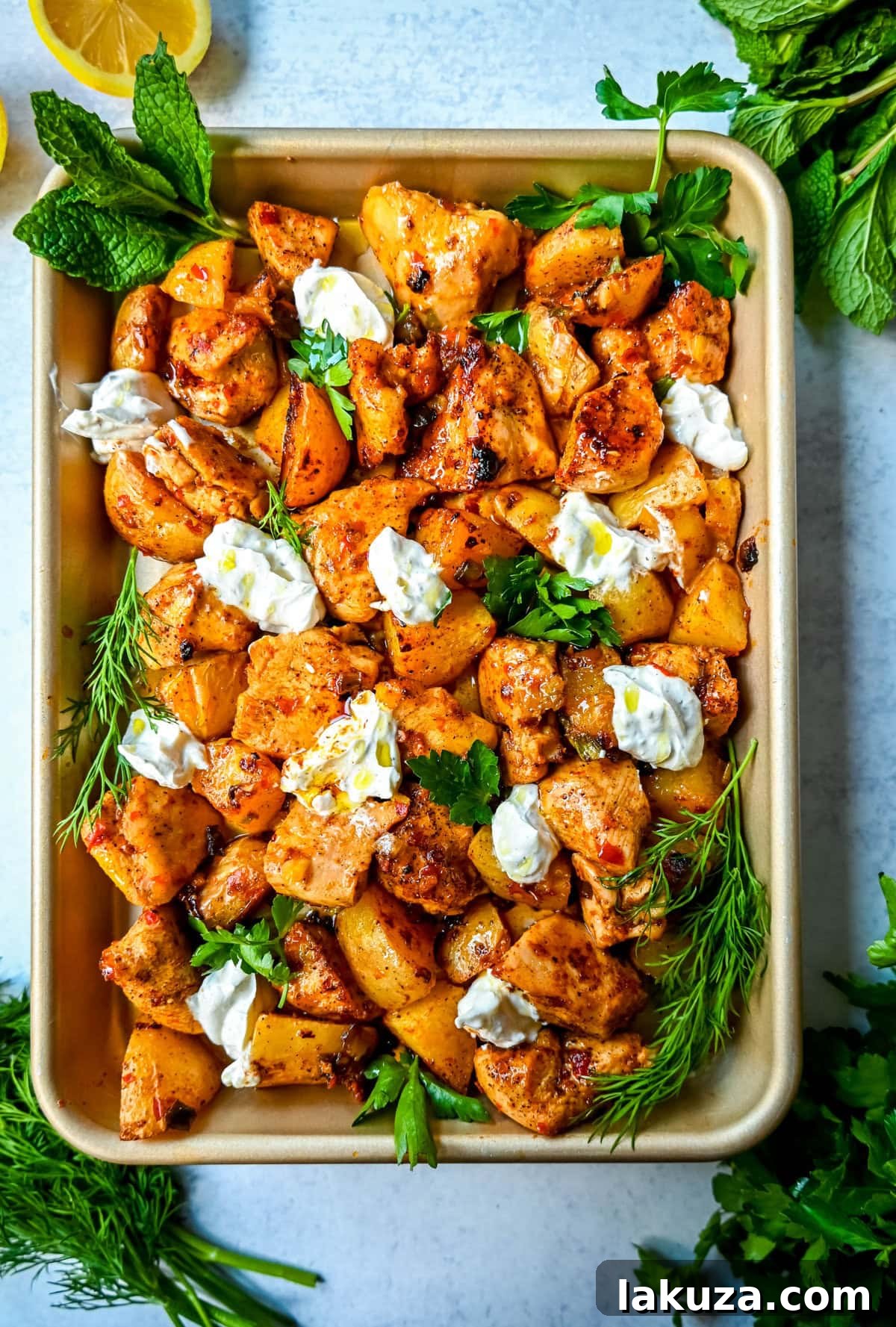 Close-up of Harissa Chicken and Roasted Potatoes, showing crispy chicken and golden potatoes on a baking sheet, ready to serve.