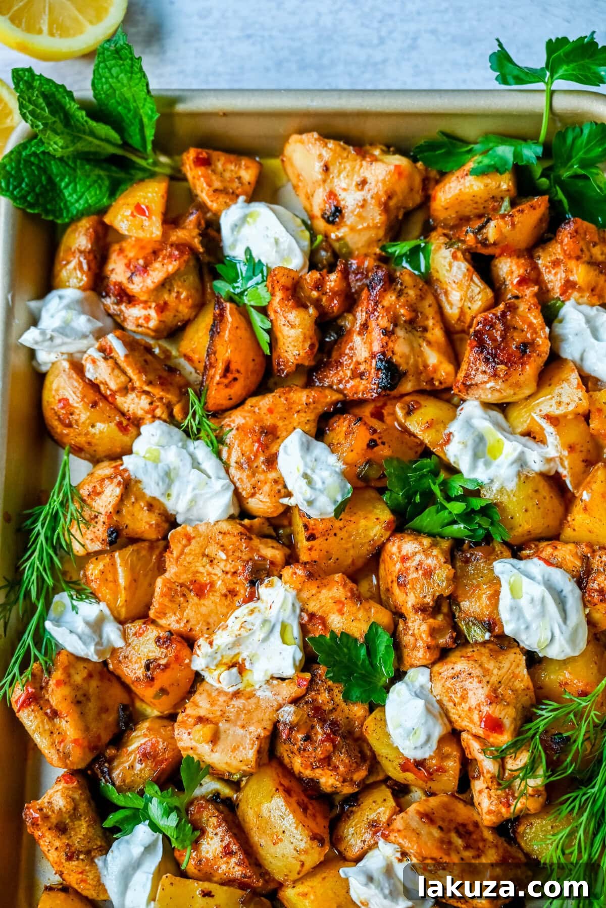 Ingredients for Harissa Chicken and Roasted Potatoes laid out, including chicken, potatoes, harissa paste, and fresh herbs.
