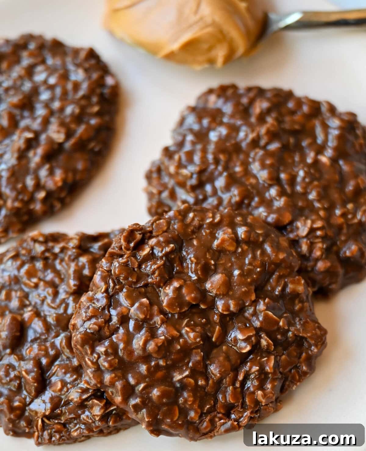 A beautifully composed shot of freshly made no-bake cookies, perfectly set on parchment paper, with a few stacked enticingly in the foreground, showcasing their rich color and inviting texture.