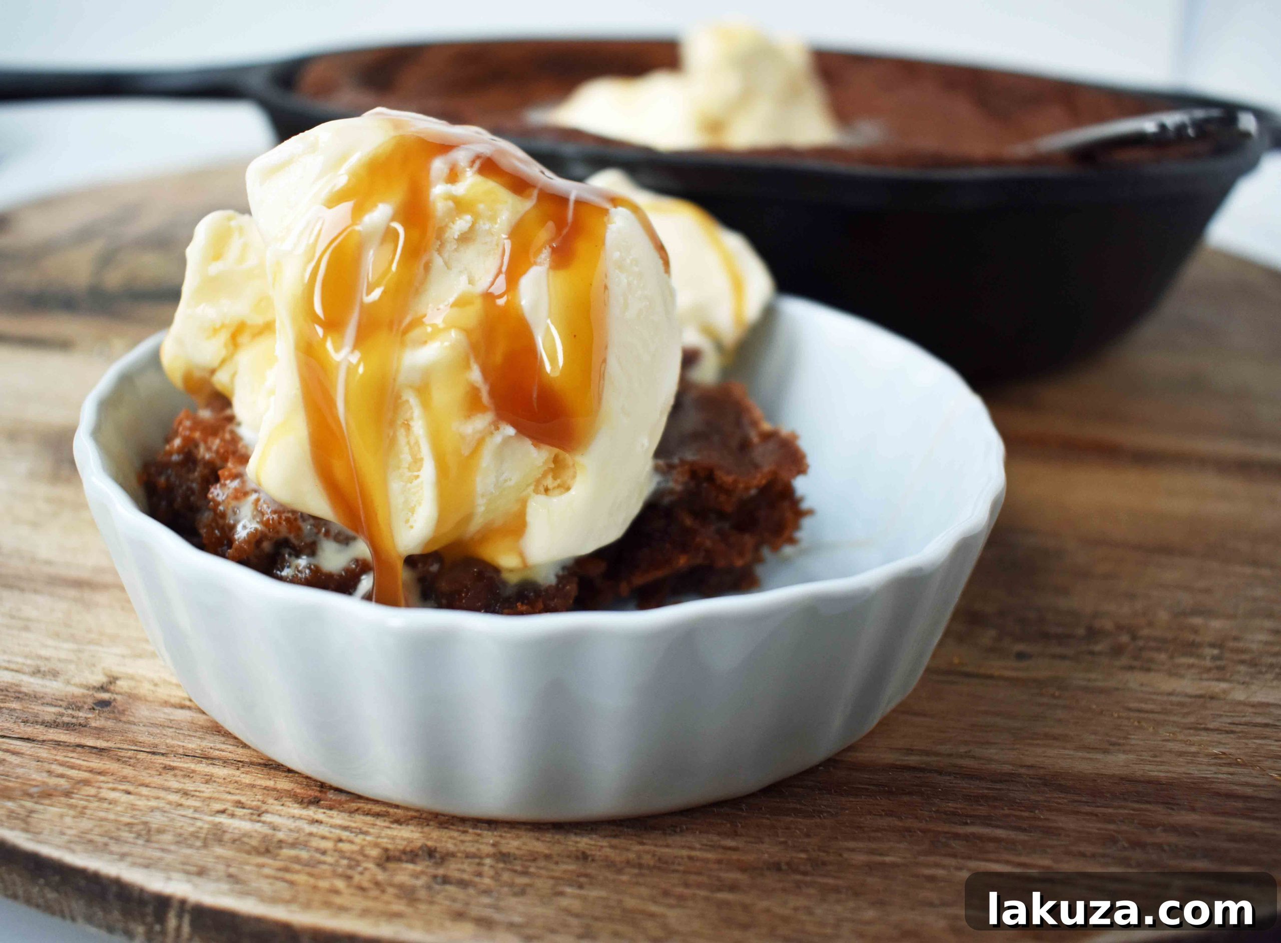 Warm Skillet Gingerbread with Golden Caramel Drizzle 3 A beautifully presented Gingerbread Skillet Cookie, generously drizzled with caramel sauce and adorned with scoops of vanilla ice cream, ready to be enjoyed.