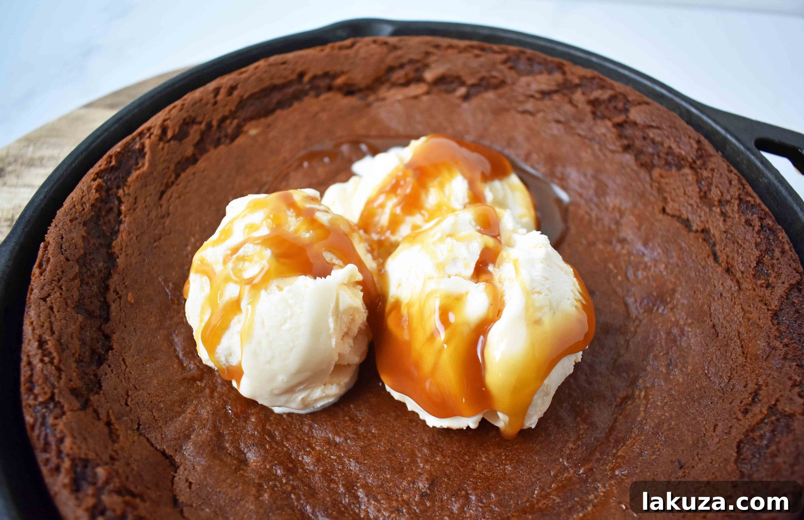 Warm Skillet Gingerbread with Golden Caramel Drizzle 4 A close-up shot of a single serving of Gingerbread Skillet Cookie, showcasing its soft texture, melted vanilla ice cream, and decadent caramel topping.