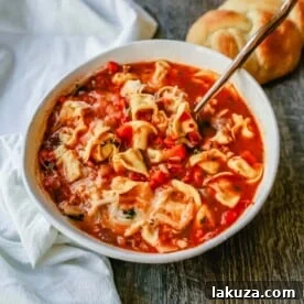 Tuscan Tortellini Vegetable Soup Robust vegetable soup with onions, garlic, carrots, tomatoes, basil, oregano, in a warm broth with creamy cheese tortellini and fresh parmesan cheese. The best tortellini soup! www.modernhoney.com #soup #tortellinisoup