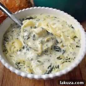 Creamy Spinach Artichoke Soup by Modern Honey. Rich and creamy parmesan cheese cream soup with spinach and artichokes. Perfect soup for a cold winter's day. www.modernhoney.com