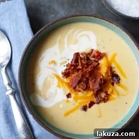 Cheesy Cauliflower Soup. A creamy cheesy cauliflower soup made with fresh cauliflower, cream, sharp cheddar cheese, and bacon. A velvety smooth cream of cauliflower soup will become a winter staple in your home! www.modernhoney.com #cauliflowersoup #cheesycauliflowersoup #creamofcauliflowersoup #soup #souprecipes