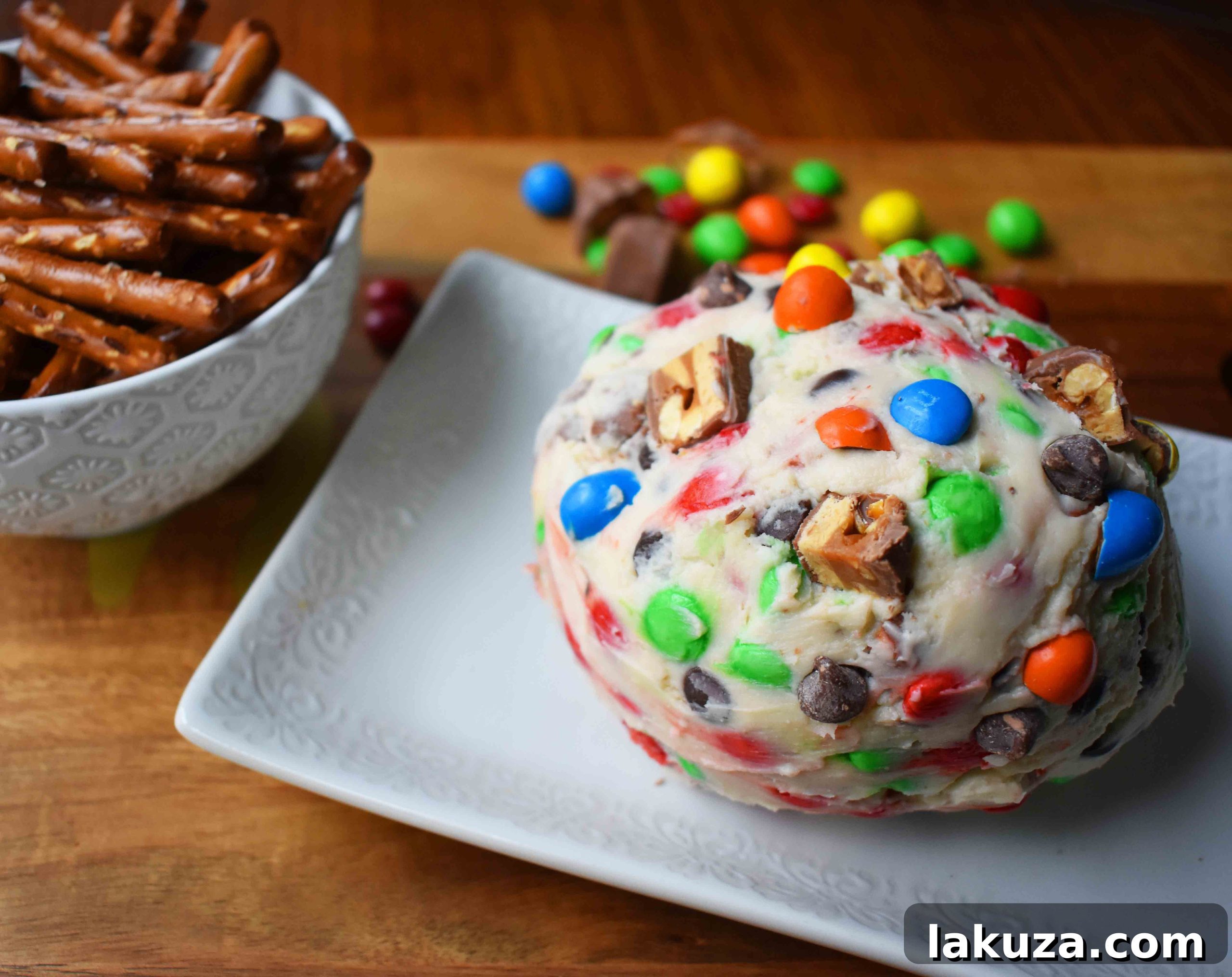 Decadent Candy Bar Cheeseball 5 Chocolate Candy Bar Cheese Ball served with an array of pretzel dippers, showcasing the texture and ready for sharing.