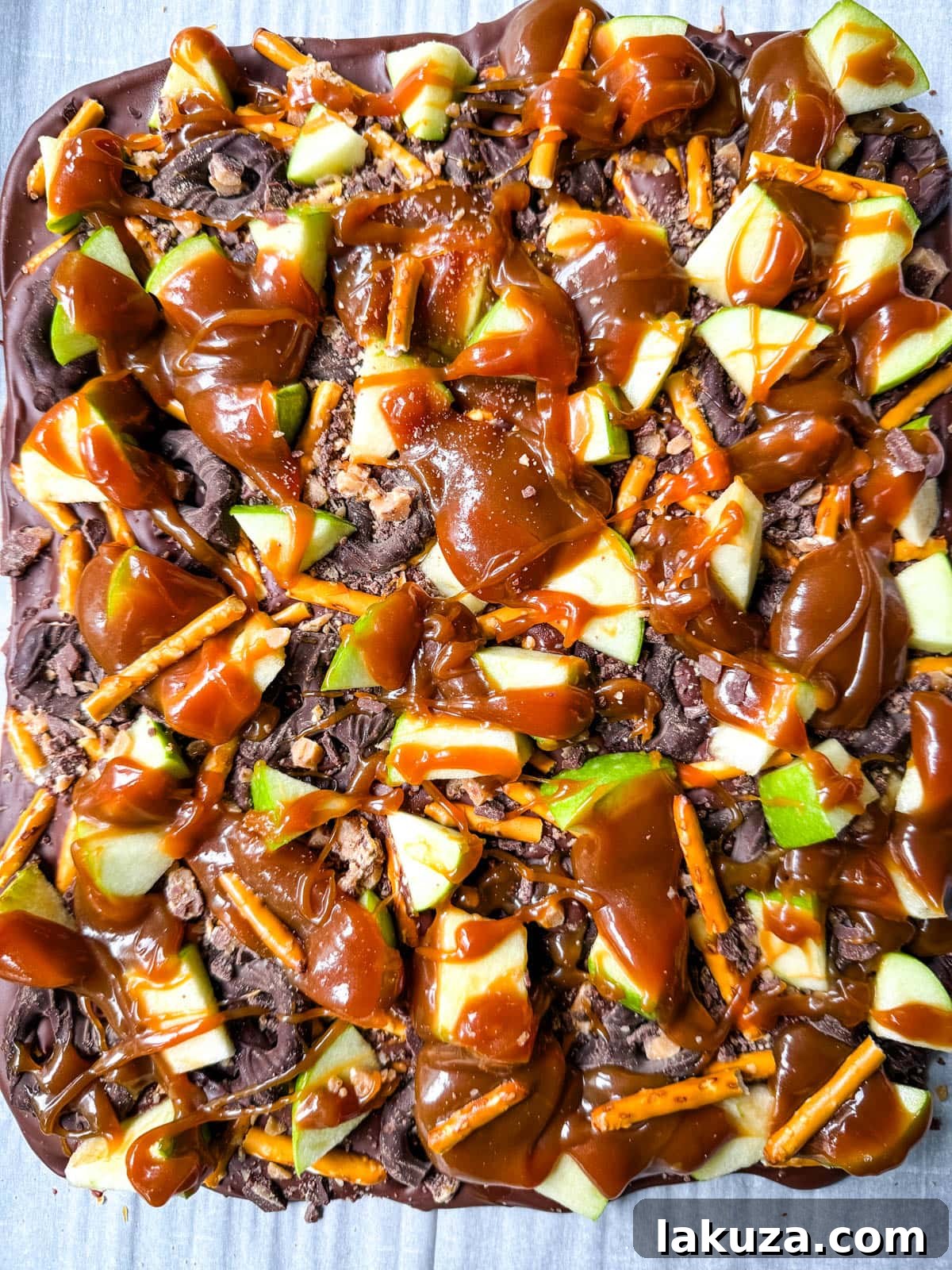Harvest Spice Caramel Apple Bark 2 Homemade Caramel Apple Bark: An easy no-bake Fall treat with fresh apples, buttery caramel, crunchy pretzels, and rich chocolate for a delicious Fall dessert.
