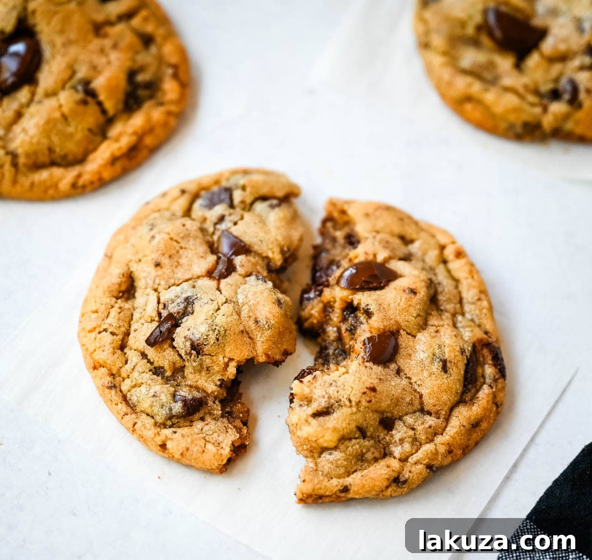Close-up of a Jacques Torres chocolate chip cookie showing the rich bittersweet chocolate discs and a sprinkle of sea salt.