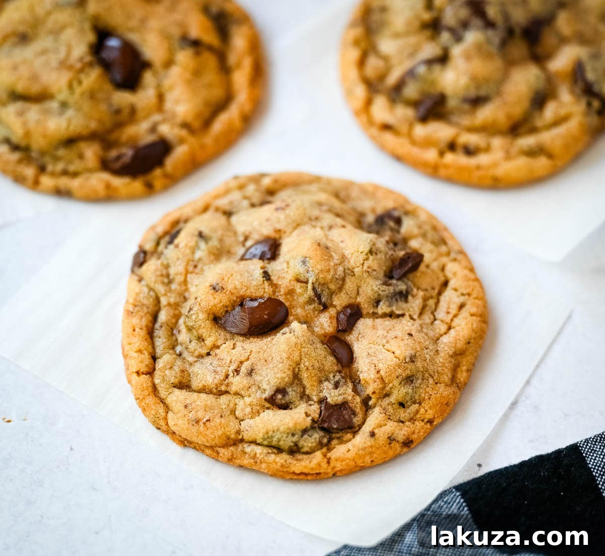 A tray of unbaked Jacques Torres chocolate chip cookie dough mounds, sprinkled with sea salt, ready for the oven.