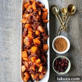 Roasted Sweet Potatoes with Pecans and Cranberries An easy, healthy side dish made with cinnamon roasted sweet potatoes, toasted pecans, and sweet and tart dried cranberries. www.modernhoney.com #sidedish #sweetpotatoes #sweetpotatoespecan #roastedsweetpotatoes