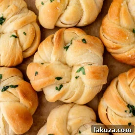 Buttery, fluffy homemade rolls tied in knot and brushed with butter. The perfect knotted rolls recipe!