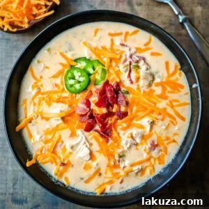 Creamy Jalapeno Chicken Bliss 7 A comforting bowl of creamy chicken jalapeño popper soup, richly garnished and ready to be enjoyed.