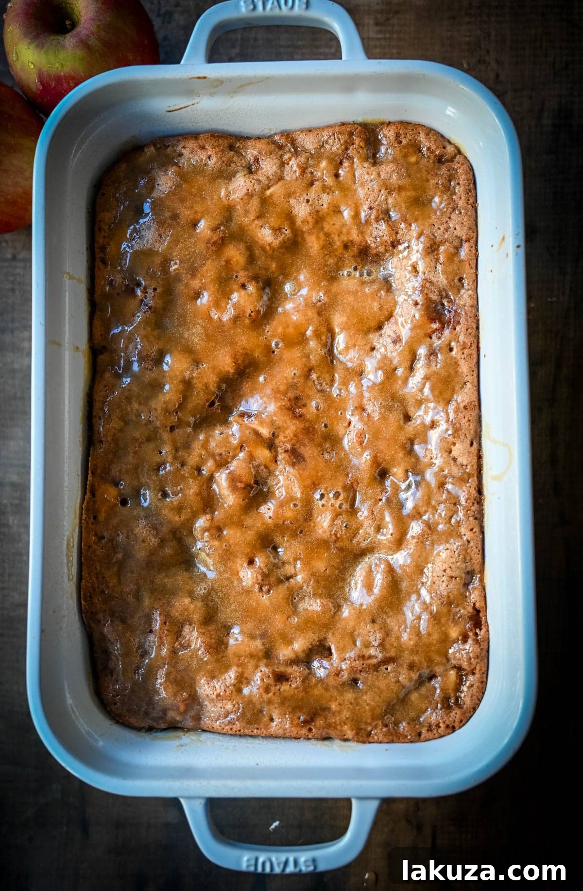A top-down view of the Apple Cake with Salted Caramel, freshly baked in a 9x13 pan, showing the golden-brown crust and glistening caramel.