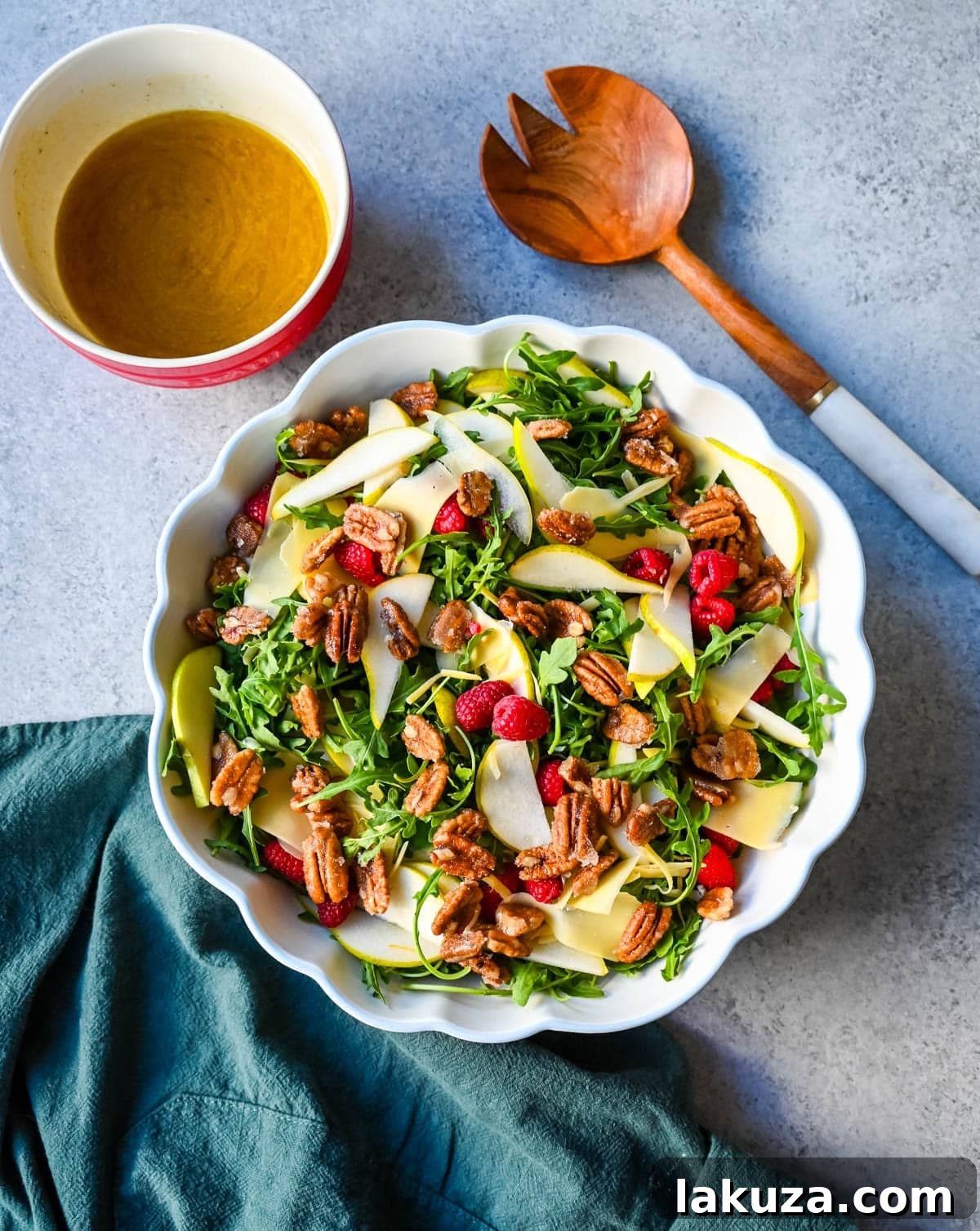 A bowl of fresh Arugula Pear Salad with Candied Pecans, ready to be served.