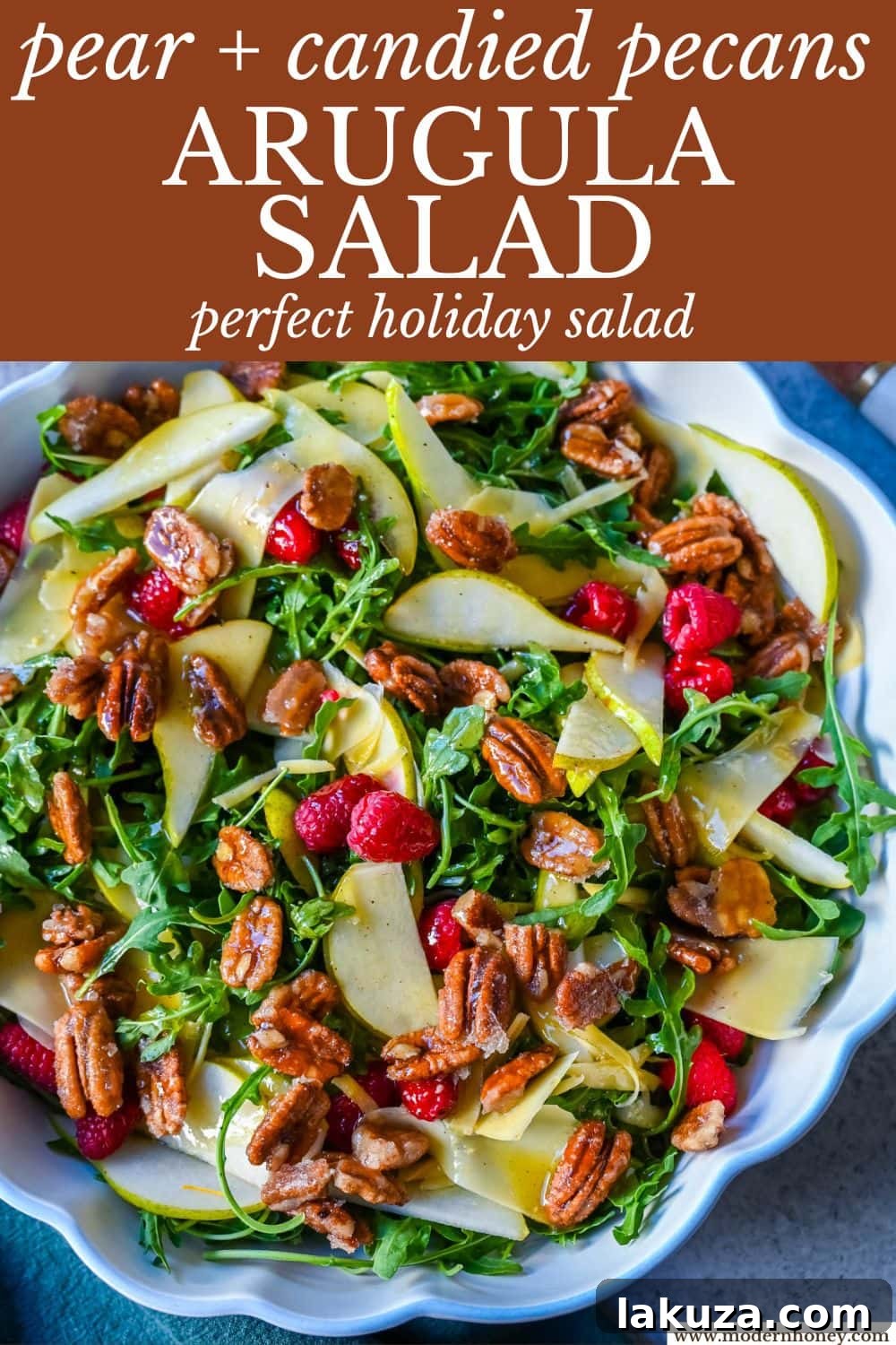 A beautifully presented Arugula Pear Salad with Candied Pecans on a white platter, ready for serving.