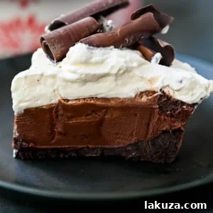 A delicious No Bake Chocolate Cream Pie, showcasing a buttery Oreo crust, a rich chocolate ganache filling, and a generous topping of sweetened whipped cream.