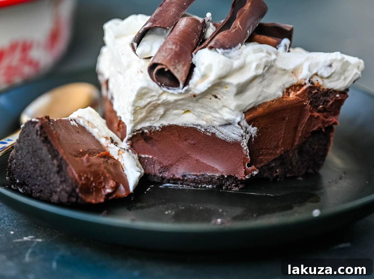 A closer view of the No Bake Chocolate Cream Pie, showcasing its smooth, dark chocolate filling and light, fluffy whipped cream with delicate chocolate shavings on top.
